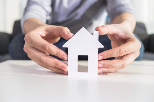 Business man holding model house